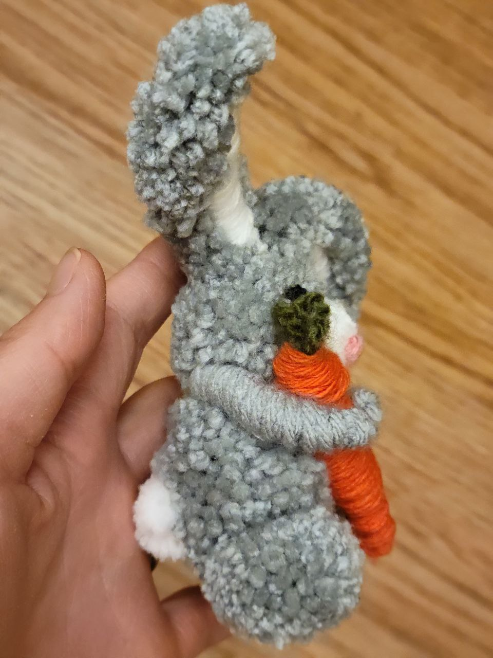 A hand holding a knitted snowman Description automatically generated with medium confidence