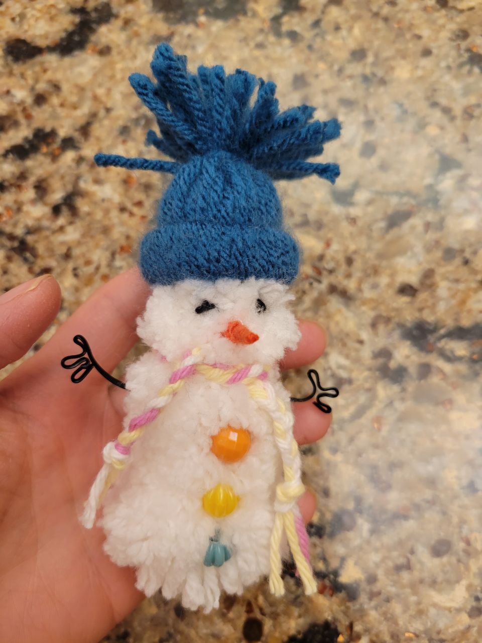 A hand holding a small snowman Description automatically generated with medium confidence